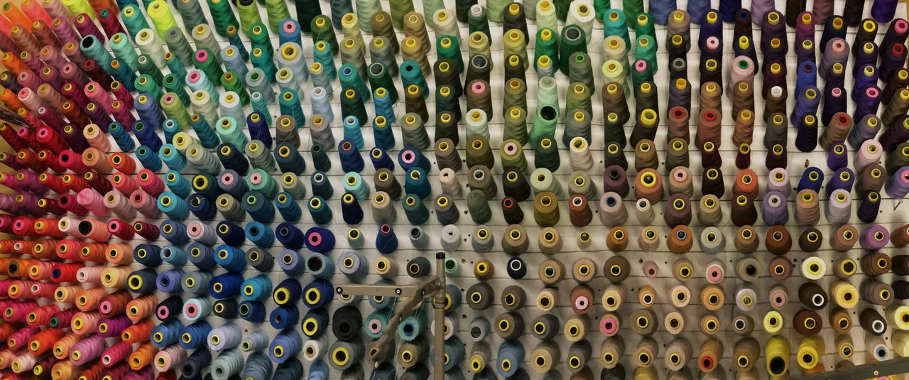 A wall of thread spools in a wide range of colors